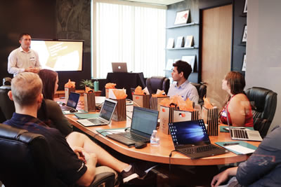 Group in Boardroom setting with laptops